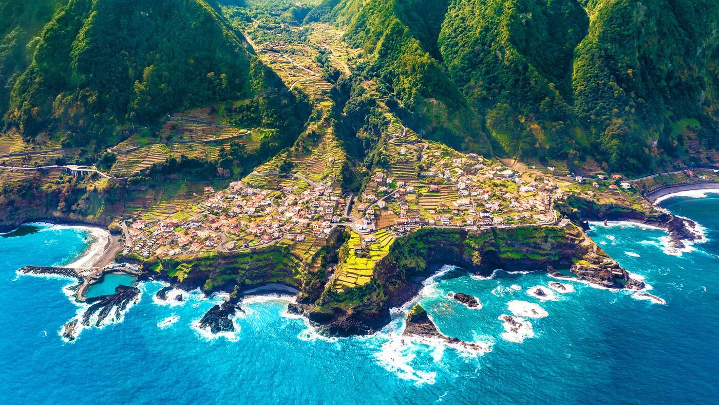 Aerial view of Madeira's green valleys meeting the Atlantic
